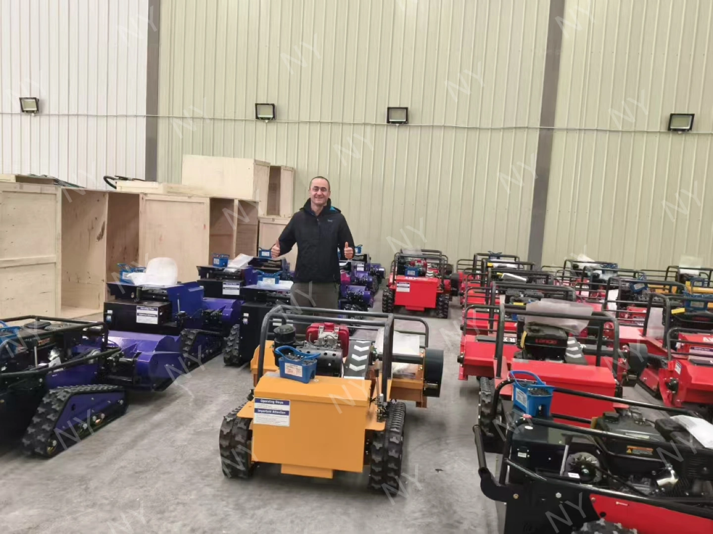 Customer visiting factory and reviewing multiple remote mower units